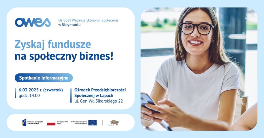 Uśmiechnięta młoda kobieta w okularach siedzi trzymając w ręku telefon.