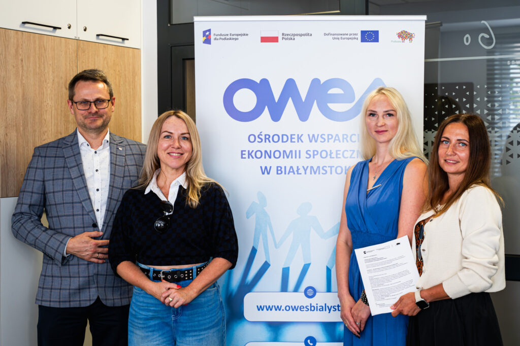 Cztery osoby (jeden mężczyzna, trzy kobiety) stoją wokół rollupu OWES Białystok