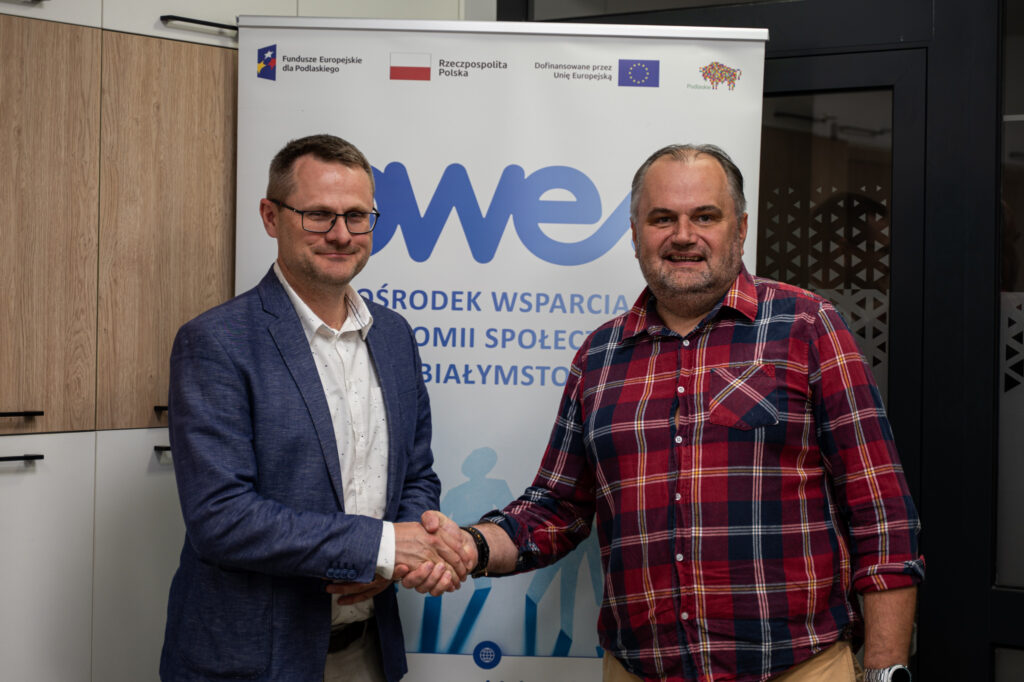Dwóch mężczyzn stoi i ściska sobie dłonie w geście gratulacji