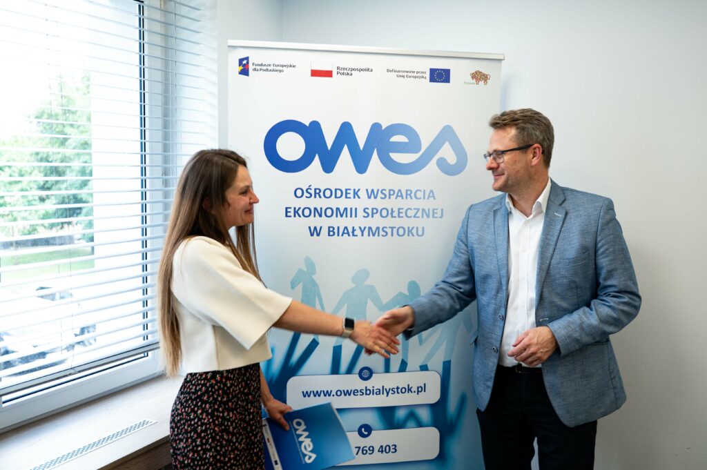 Kobieta i mężczyzna podają sobie ręce w geście gratulacji