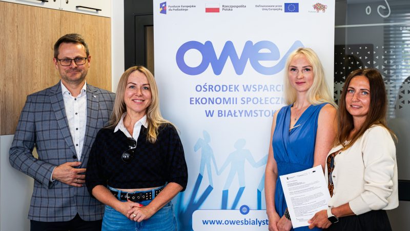Cztery osoby (jeden mężczyzna, trzy kobiety) stoją wokół rollupu OWES Białystok