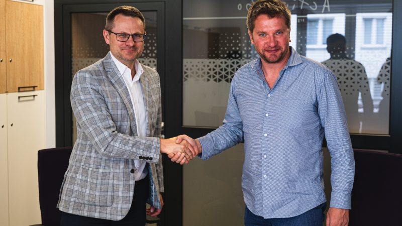 Dwaj mężczyźni podają sobie ręce gratulując podpisanej umowy.